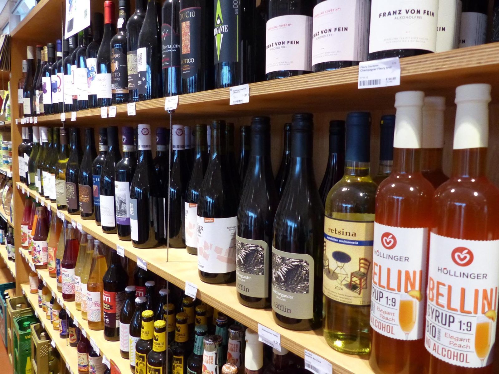 Weinregal im Laden mit Rotweinen, Schaumwein und alkoholfreien Getränken